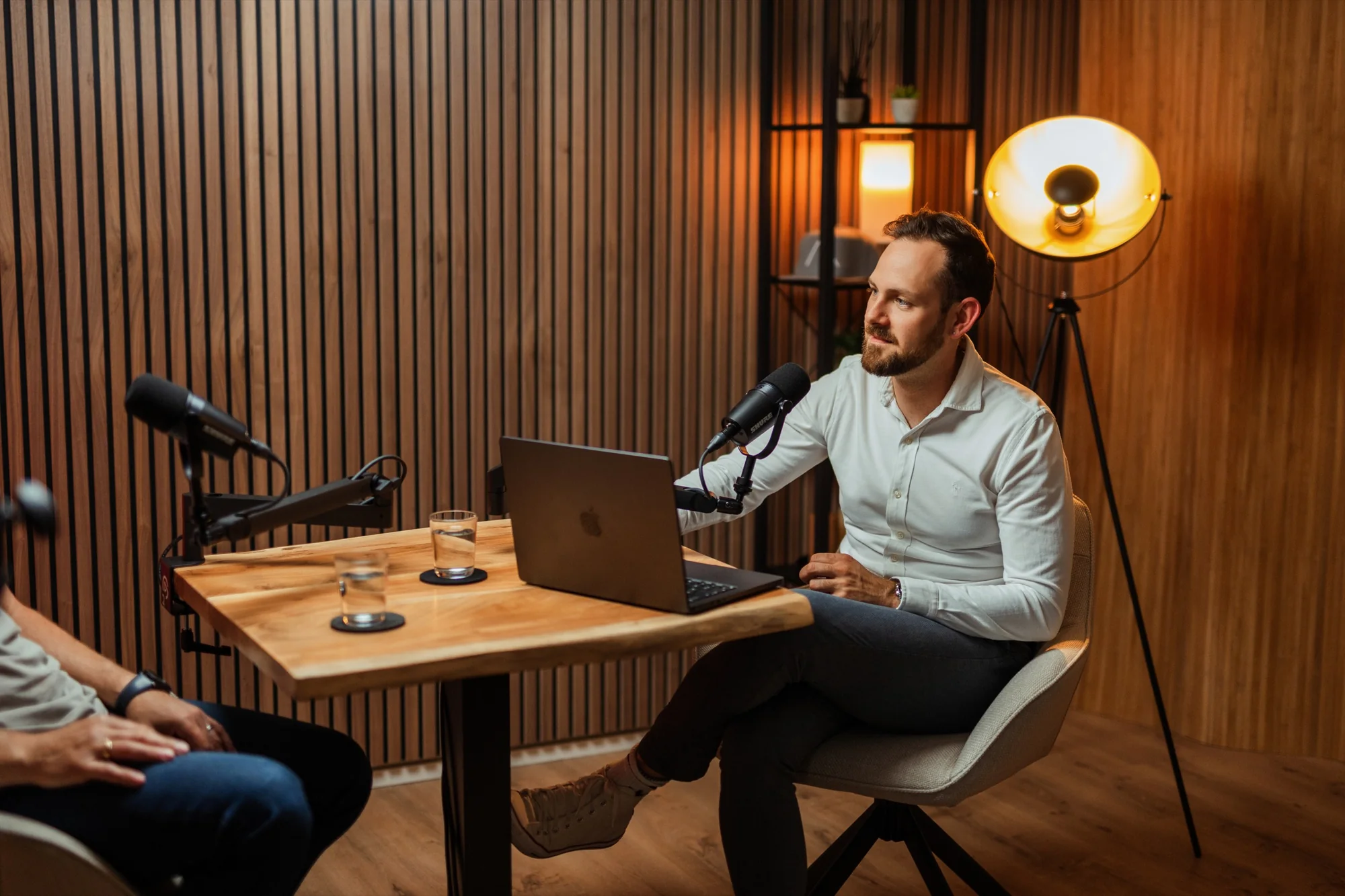 Florian am Podcasttisch mit Mikrofon und Laptop